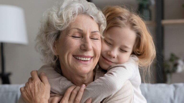 A little granddaughter hugs her grandmother