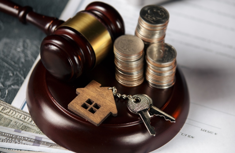 Gavel with keys, coins and a picture of a house on it