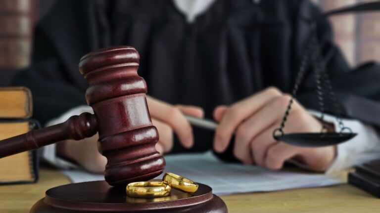 Judge gavel on with two golden wedding rings